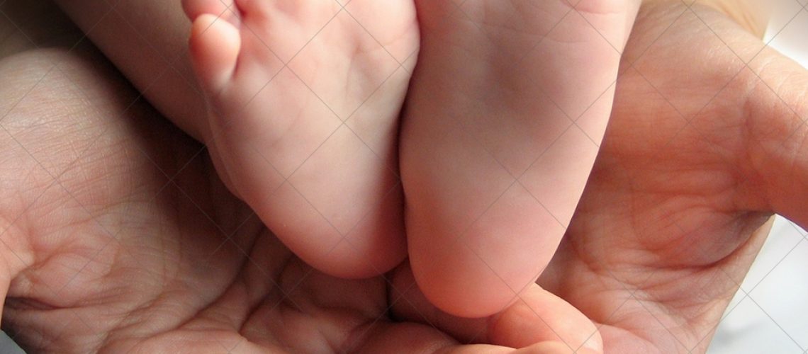 Mom checks reflex child moving her fingers on foot